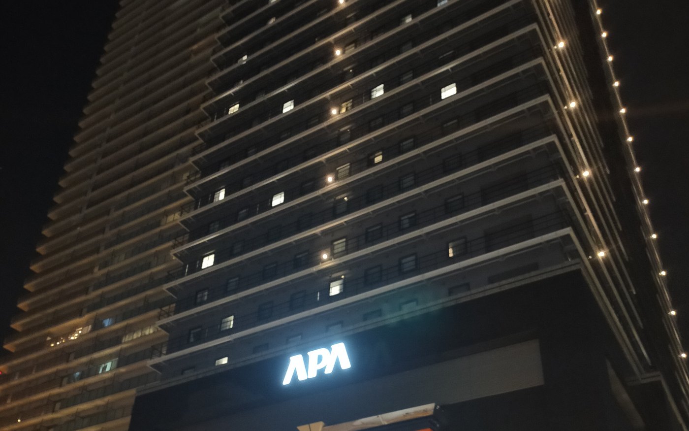 The APA Hotel and Resort Osaka Namba Ekimae Tower at night, seen from street level