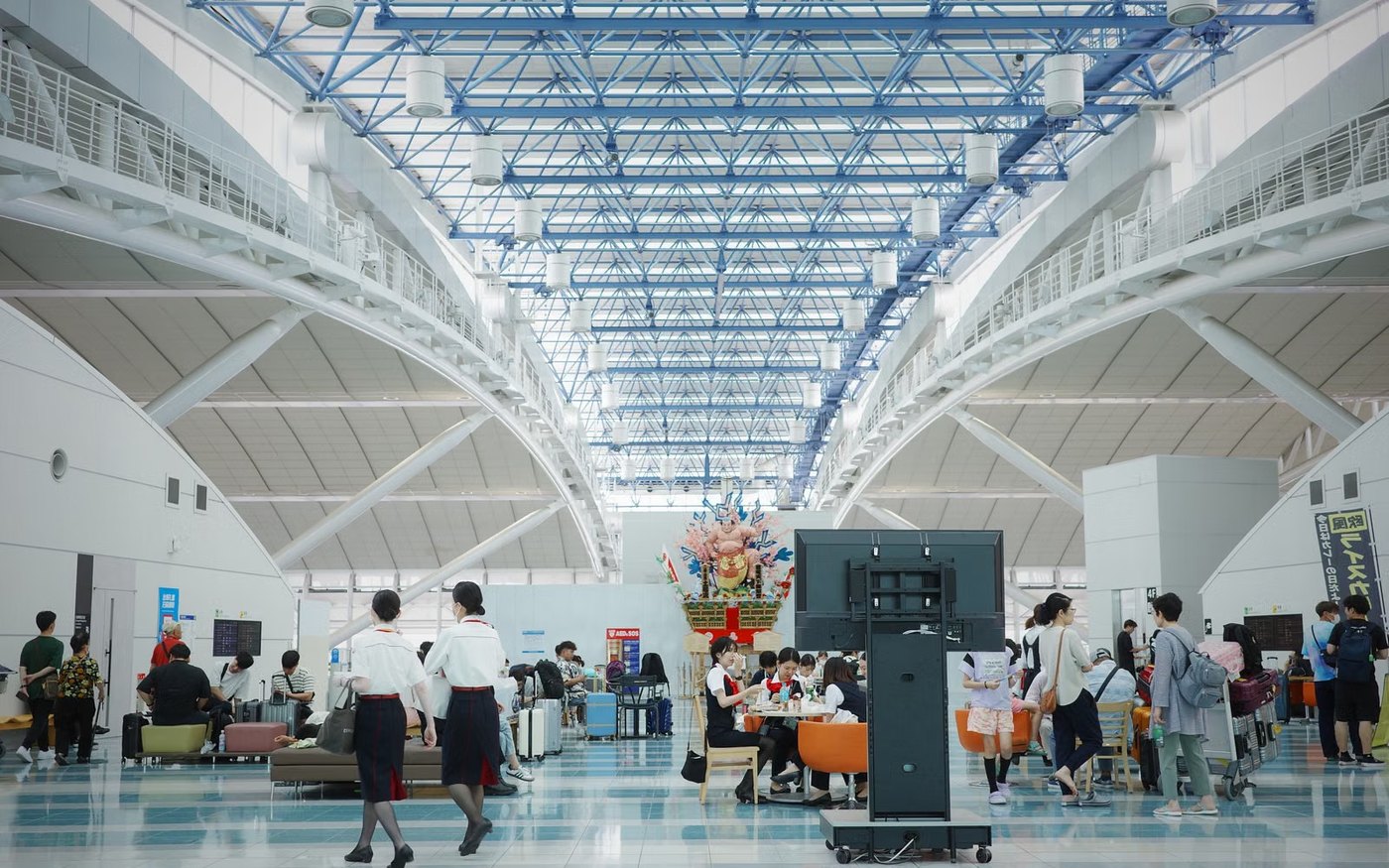 Travellers crossing the arrivals lobby of a Japanese airport