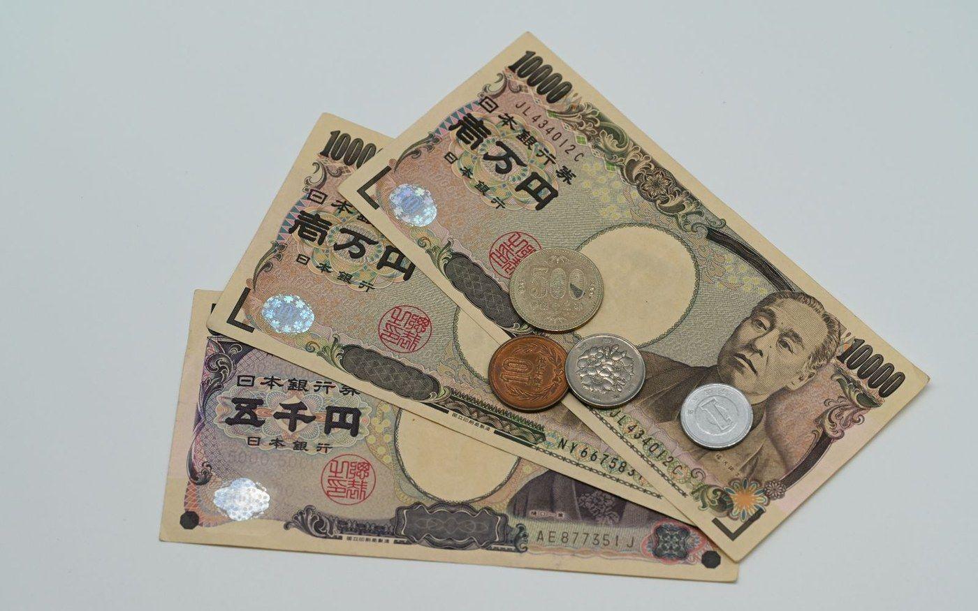 Yen banknotes and coins laid out on a surface