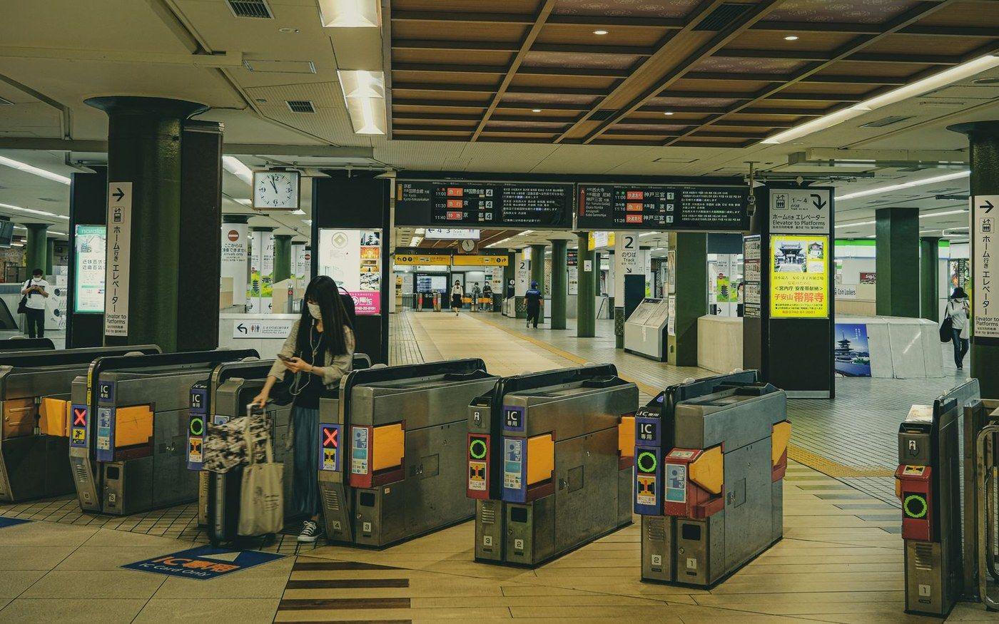 Automatic ticket gates at a Japanese railway station with a passenger passing through