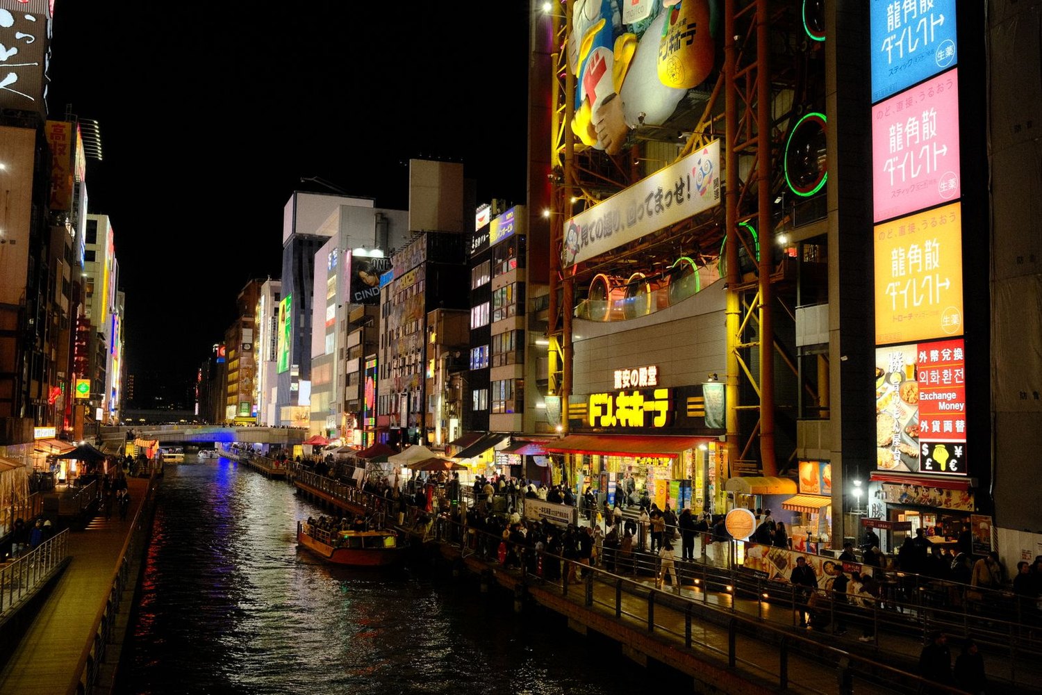 The Dotonbori canal at night, lit signs and crowds along the water