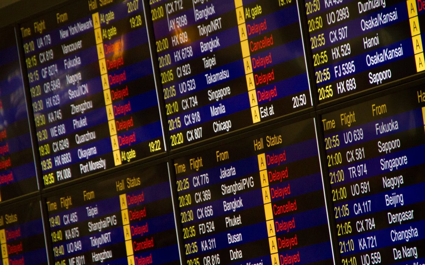 A digital flight board listing arrivals and departures at an airport