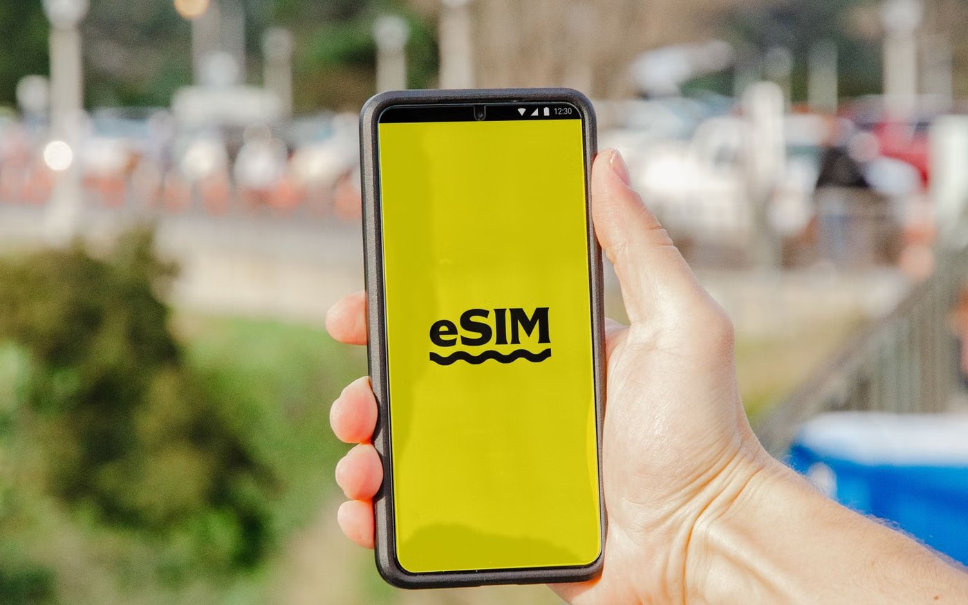 A hand holding a phone showing an eSIM screen