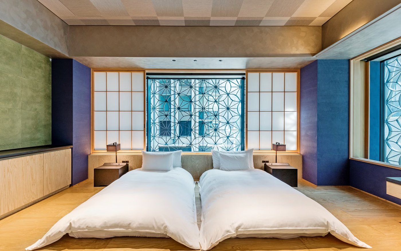 A modern Japanese hotel room with twin beds and shoji screens