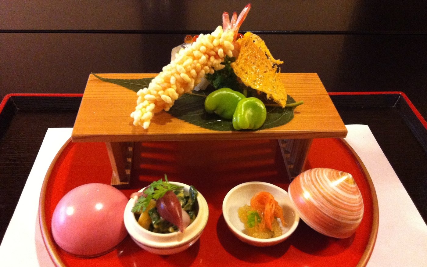 A kaiseki course laid out in small dishes on a lacquered tray