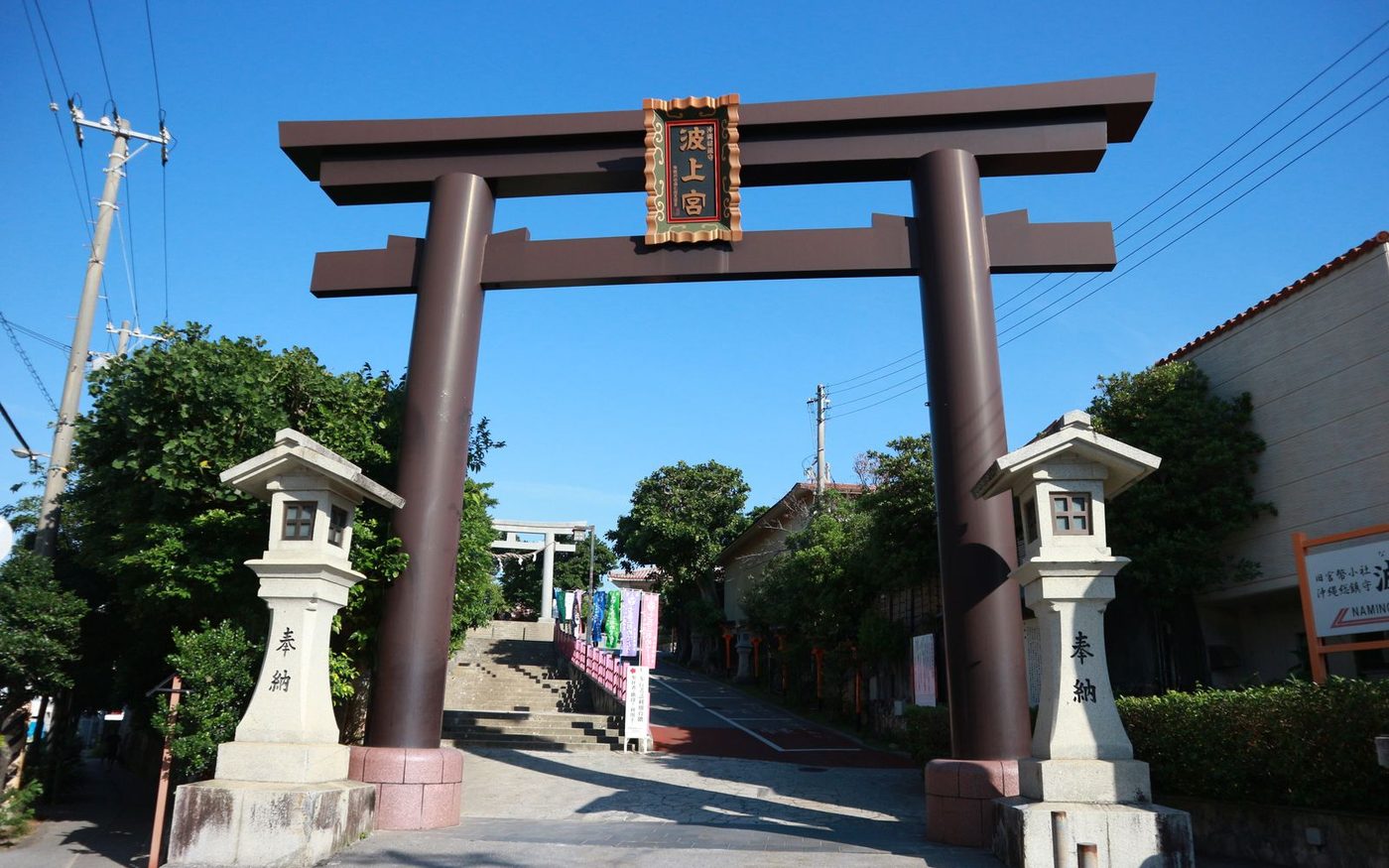 A large stone torii gate at the top of steps, with lanterns either side