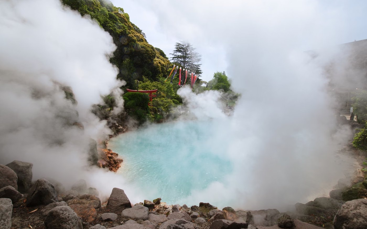 Steam rising over a hot spring in Beppu, with rocky ground around it