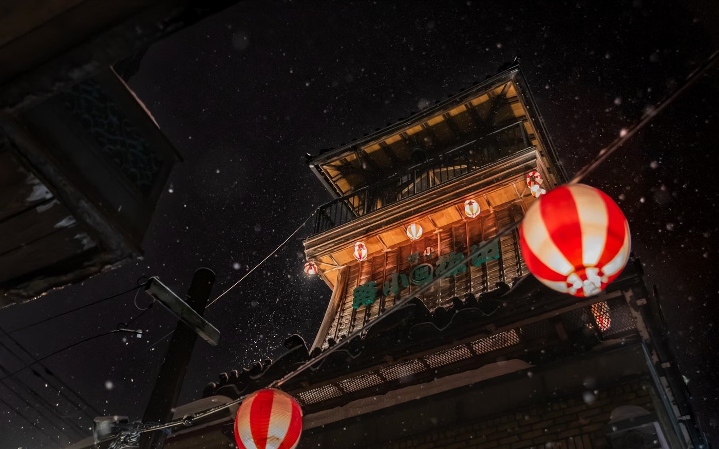 Red lanterns lit on a wooden building frontage after dark