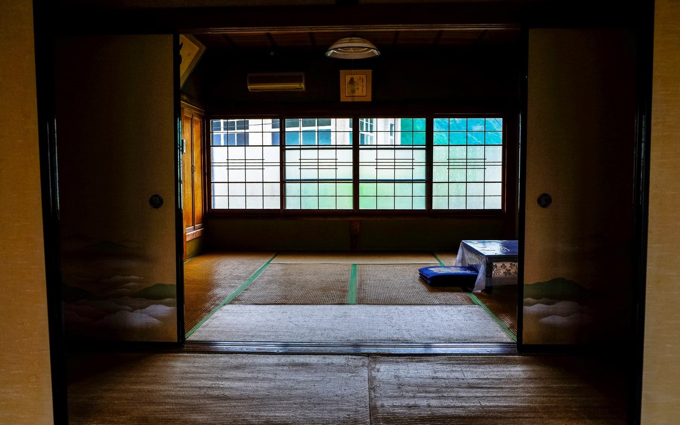 A tatami room in a Japanese inn with a low table and a garden beyond the glass