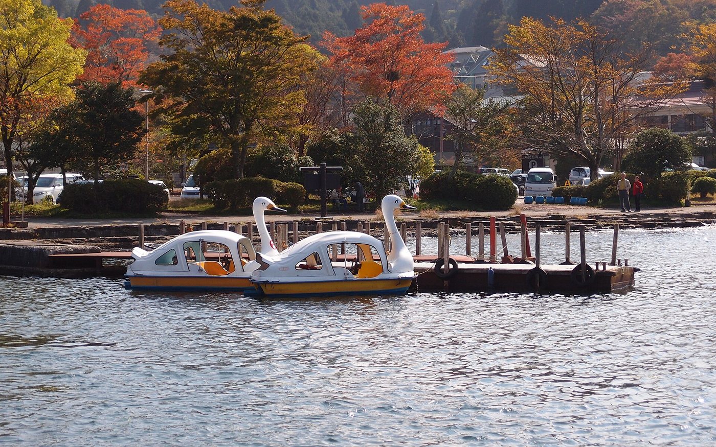 A Hakone Sightseeing Cruise ship under way on Lake Ashi, wooded hills behind