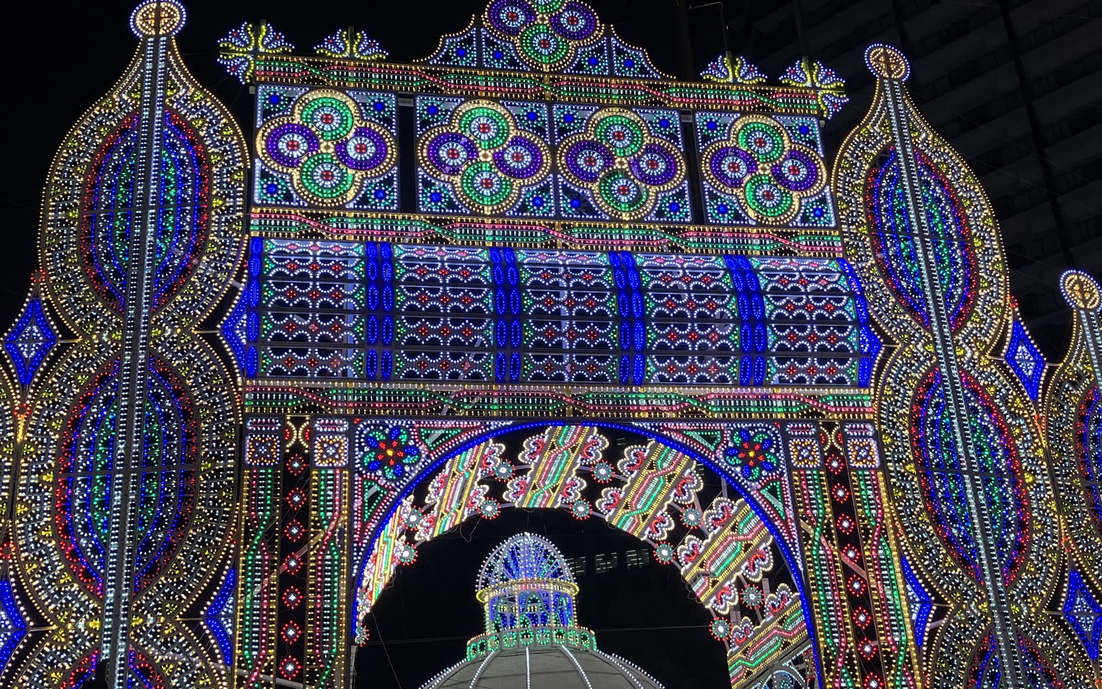 An ornate arch of coloured light bulbs at Kobe Luminarie, seen at night