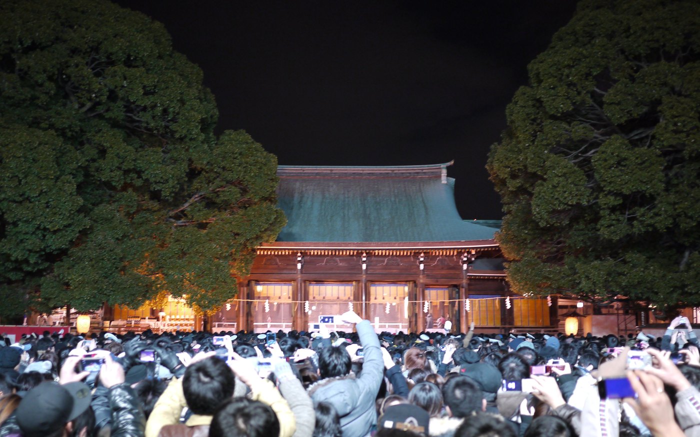 A crowd at a Japanese shrine on New Year's Eve, packed behind a rope line