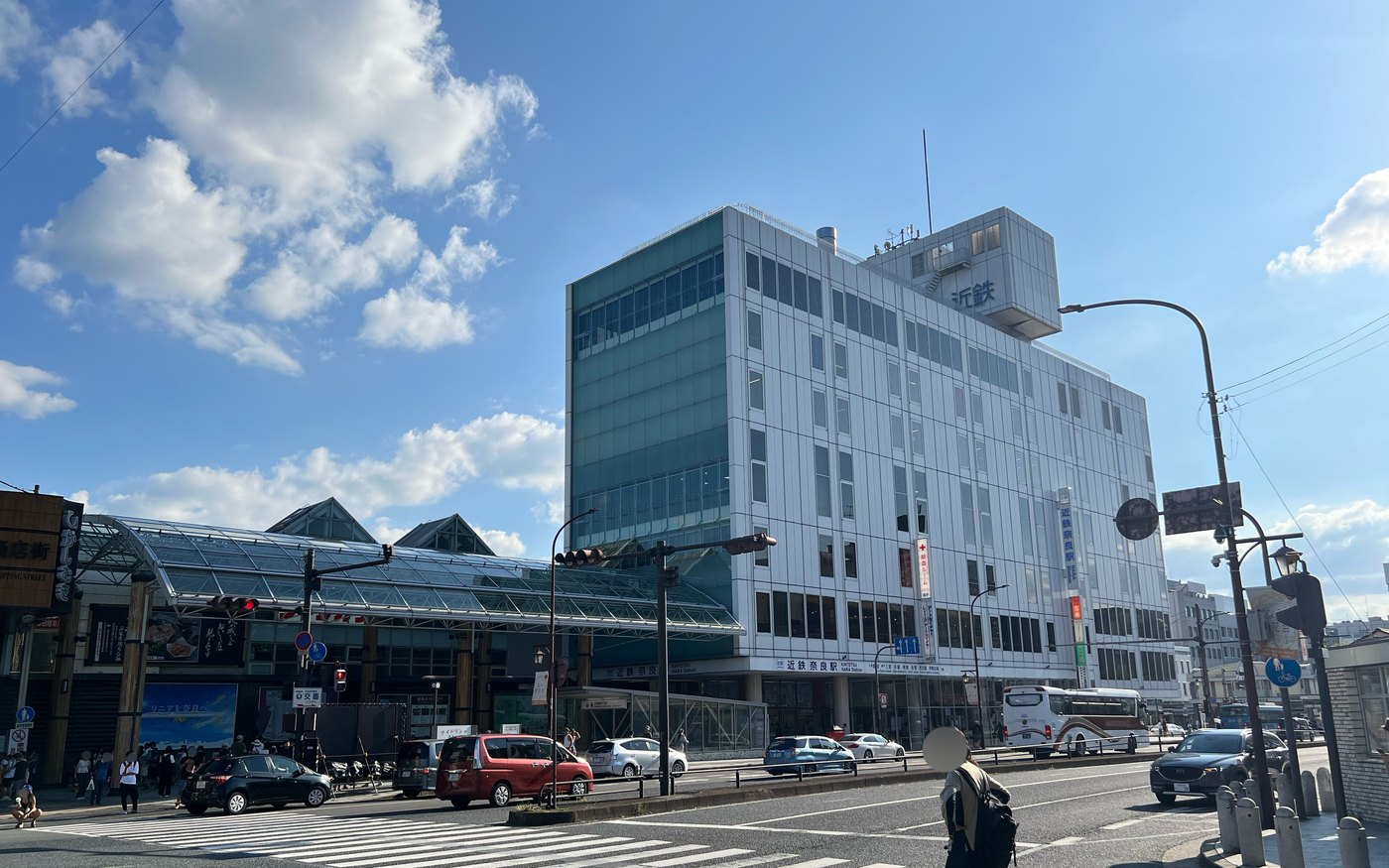 The facade of Kintetsu Nara Station with traffic passing in front