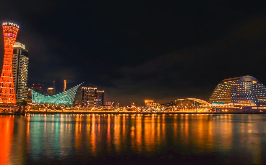 Kobe harbour at night, buildings lit and reflecting on the water