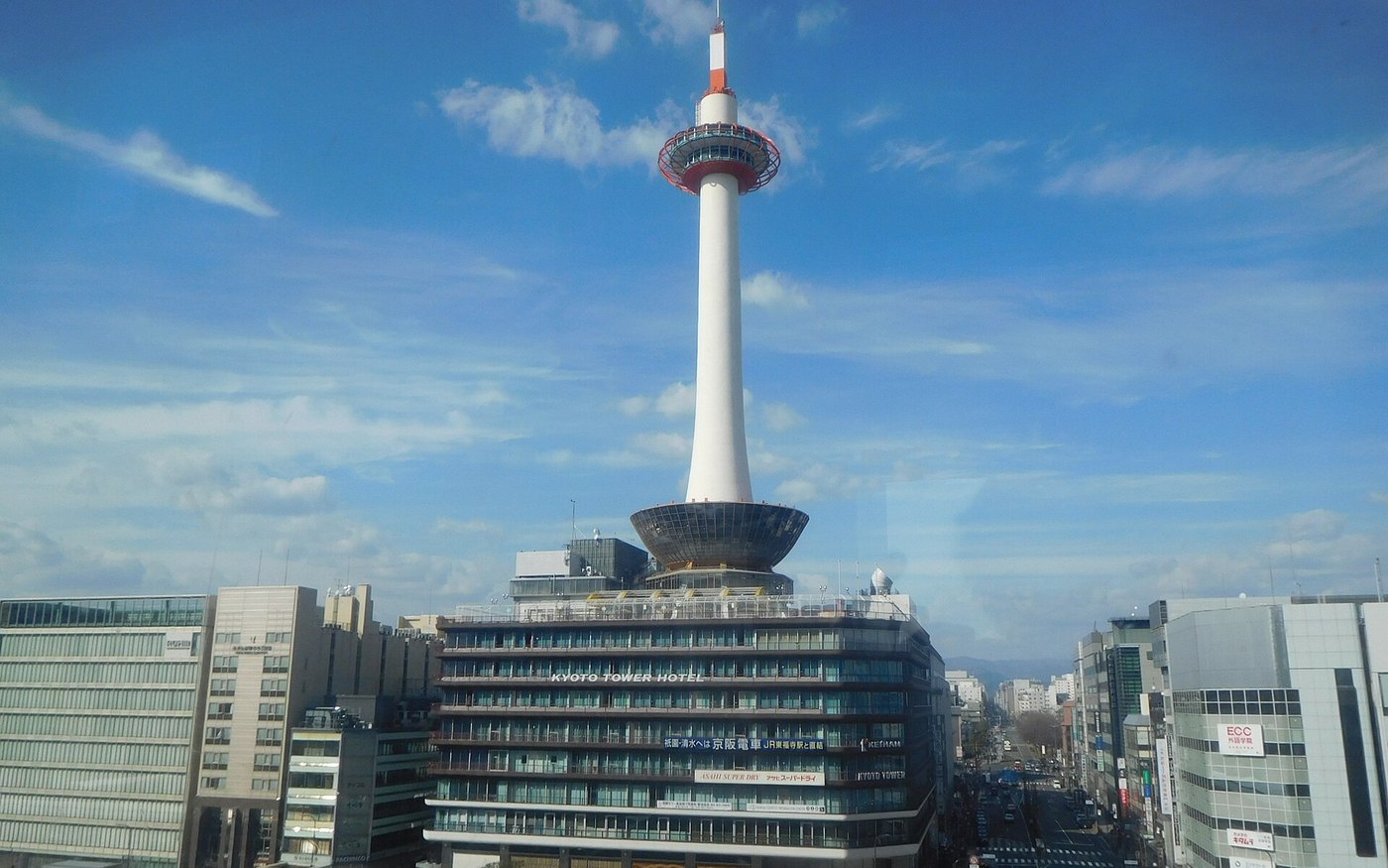 Kyoto Station's long glass building with Kyoto Tower standing behind it