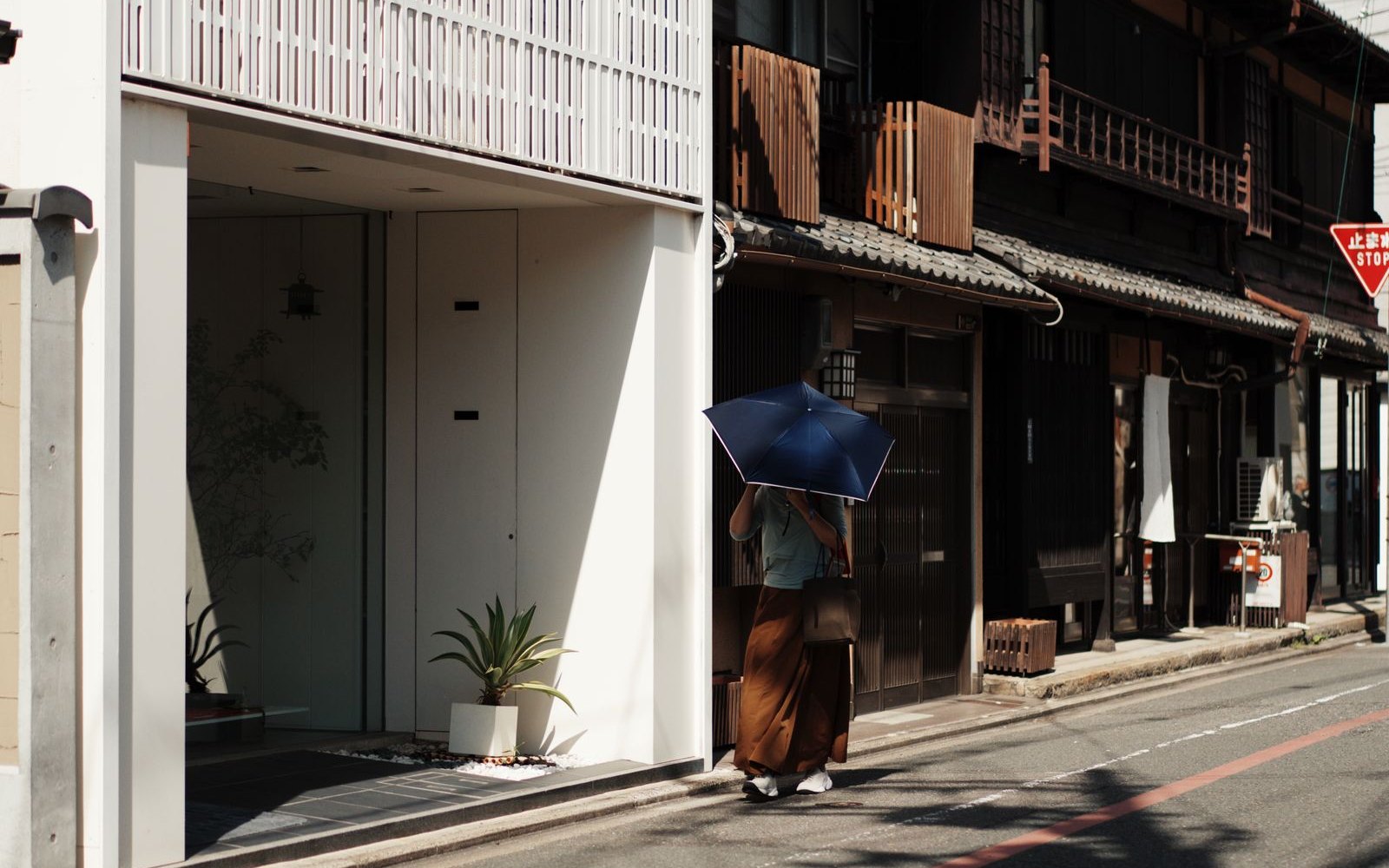 A Kyoto street at dusk, low wooden buildings under a wide sky