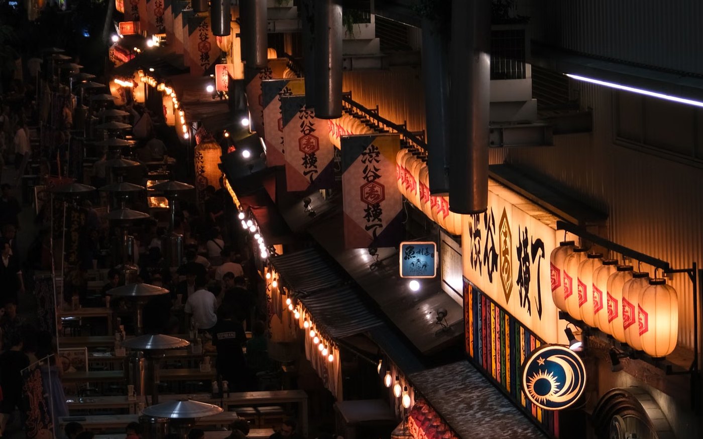 Night food stalls along the river at Nakasu in Fukuoka, lanterns lit and diners at the counters