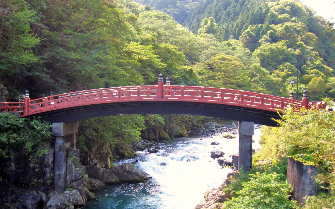 The vermilion Shinkyo bridge over the Daiya river at Nikko, framed by dark trees