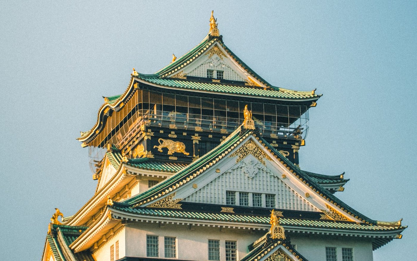 Osaka Castle's main tower in daylight with visitors in the grounds