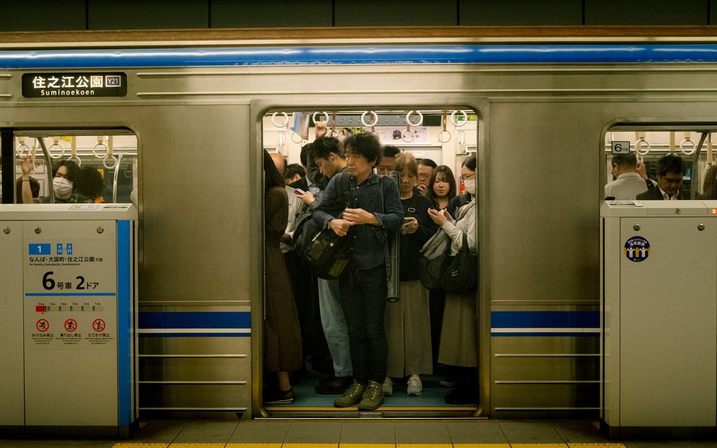 A Midosuji Line train at a subway platform in Osaka, passengers boarding