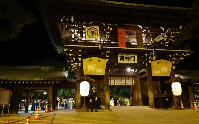 A shrine gate at New Year, lit after dark