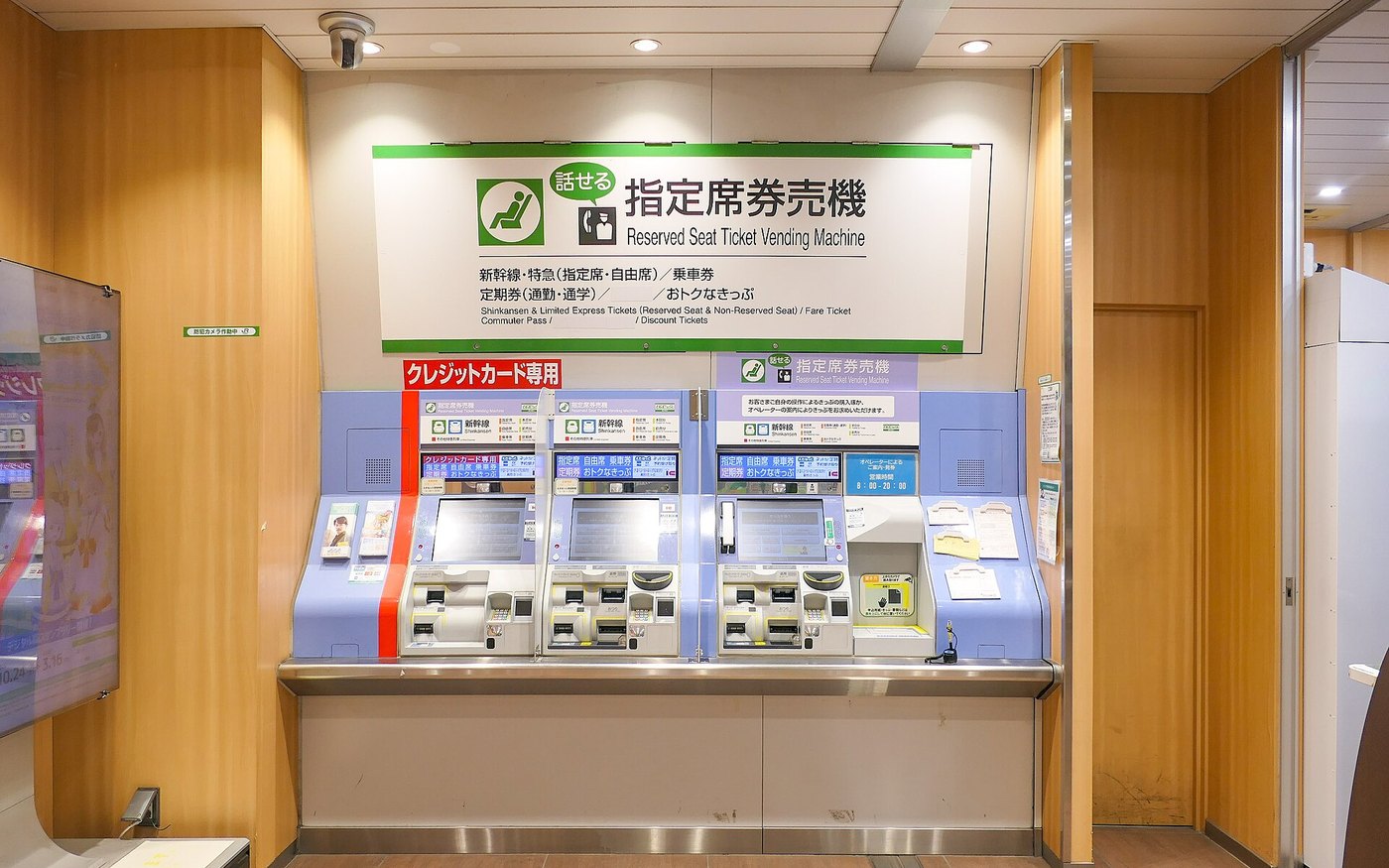 Three blue reserved-seat ticket machines under a green JR East sign at Yotsuya Station