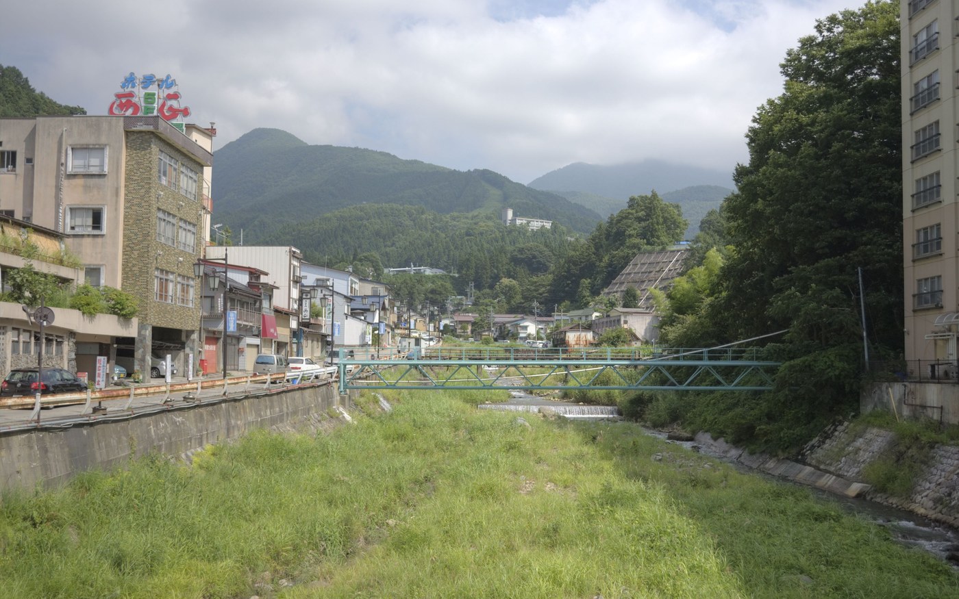 The narrow street of Shibu Onsen with wooden inns on both sides and a stepped lane climbing between them