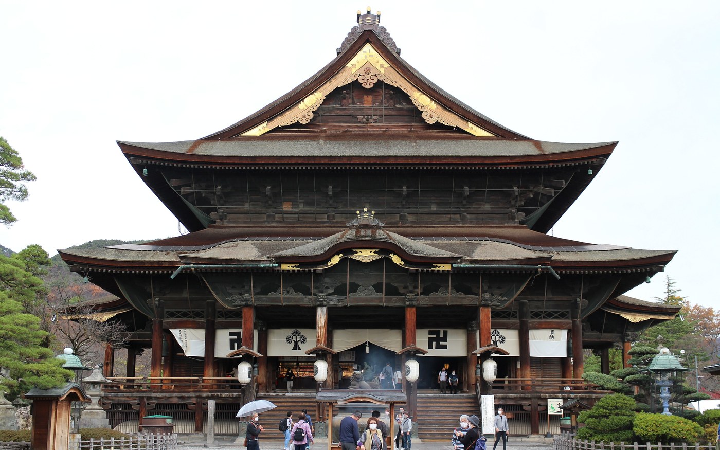 The wide wooden facade and stone steps of the main hall at Zenko-ji temple in Nagano