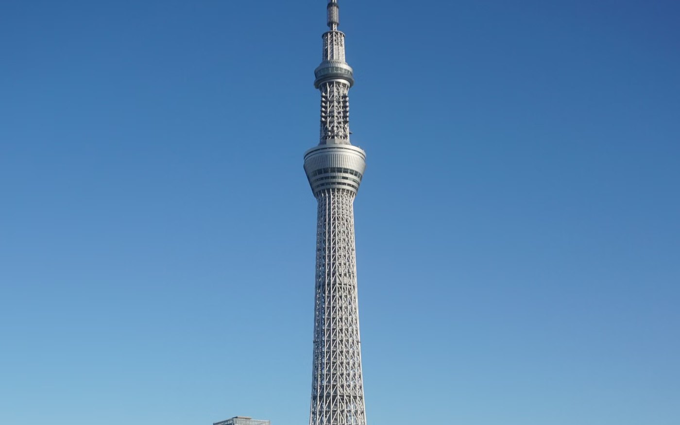 Stunning view of Tokyo Skytree with clear blue sky reflecting on the river below
